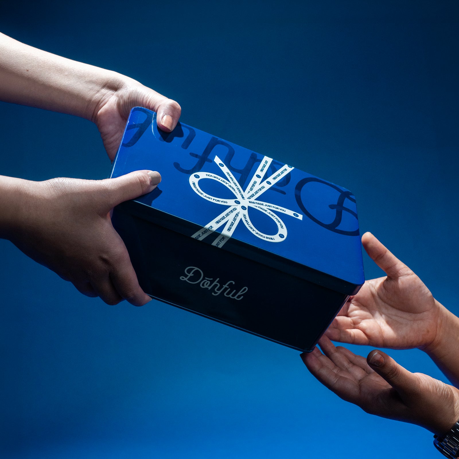 A Dohful gift box being handed to someone